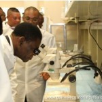 The President of Equatorial Guinea observing through a microscope the advances in the vaccine’s research.